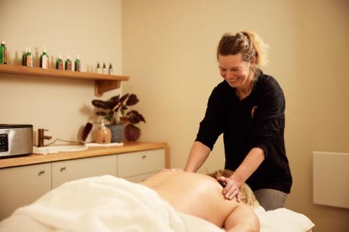 a woman is giving a man a massage at Van der Valk Hotel Tiel in Tiel