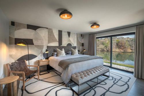 a bedroom with a large bed and a large window at Cradle Boutique Hotel in Lanseria