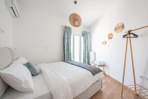 a white bedroom with a bed and a window at Kastela's Harbor Retreat with Jacuzzi in Piraeus