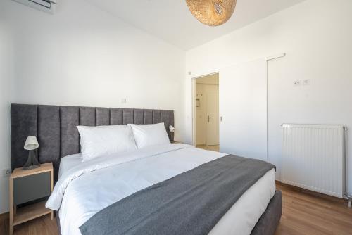 a bedroom with a large bed with a gray headboard at Kastela's Harbor Retreat with Jacuzzi in Piraeus