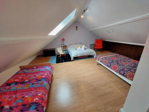 - une chambre mansardée avec un lit et une table dans l'établissement Maison spacieuse avec jardin proche Disney, à Tancrou
