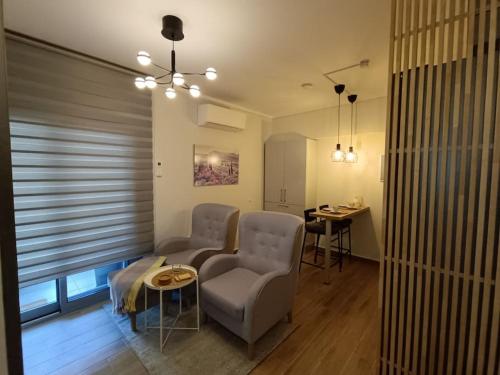 a living room with two chairs and a table at Sotherm apartment in Thermi