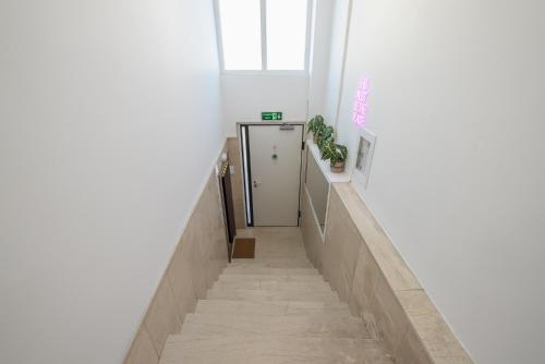 a hallway with a stairway leading up to a door at Kastela's Harbor Retreat with Jacuzzi in Piraeus