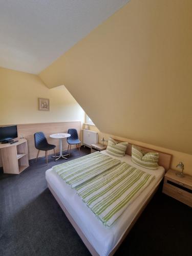 a bedroom with a bed and a table and chairs at Pension Schmidt Bad Kösen in Bad Kösen
