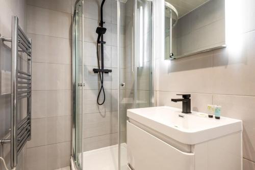 a white bathroom with a sink and a shower at Bright 1 Bedroom Apartment in Central Doncaster in Doncaster