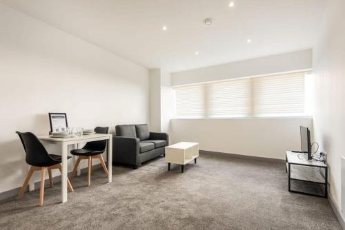 - un salon avec un canapé et une table avec des chaises dans l'établissement Comfortable 1 Bedroom Central Doncaster Apartment, à Doncaster