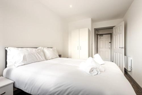 a bedroom with a white bed with a white pillow at Lovely 1 Bedroom Apartment in Central Doncaster in Doncaster