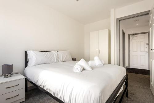 Cosy 1 Bedroom Apartment in Central Doncaster في دونكاستير: غرفة نوم بسرير ابيض كبير مع وسادتين