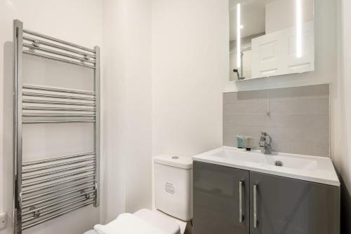 Cosy 1 Bedroom Apartment in Central Doncaster في دونكاستير: حمام ابيض مع مرحاض ومغسلة