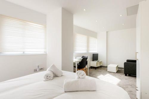 een witte slaapkamer met een bed en een bureau bij Comfortable Studio Apartment in Central Doncaster in Doncaster