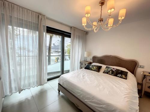 een slaapkamer met een bed en een groot raam bij Direct view to the red carpet, 2 bedroom 311 in Cannes
