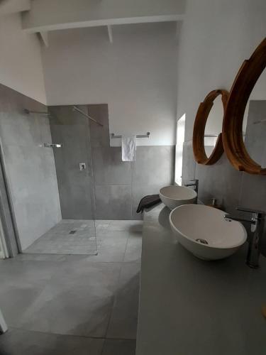a bathroom with two sinks and a glass shower at C-Rock Holiday Home Jacobs Bay in Jacobs Bay