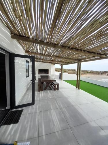 a patio with a wooden ceiling and a table at C-Rock Holiday Home Jacobs Bay in Jacobs Bay