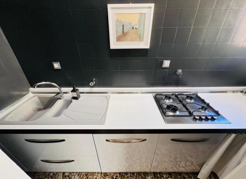 a kitchen with a sink and a stove at Bononia Host - Beverara in Bologna