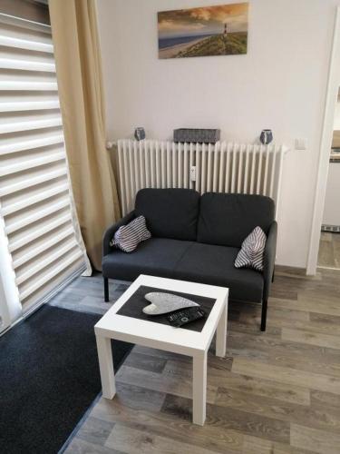 ein Wohnzimmer mit einer Couch und einem Couchtisch in der Unterkunft FEWO Kutsch Watt Nr.3 in Cuxhaven