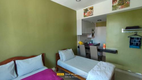 ein kleines Zimmer mit 2 Betten und einer Küche in der Unterkunft ZH Studio Apartment Gua Musang in Gua Musang