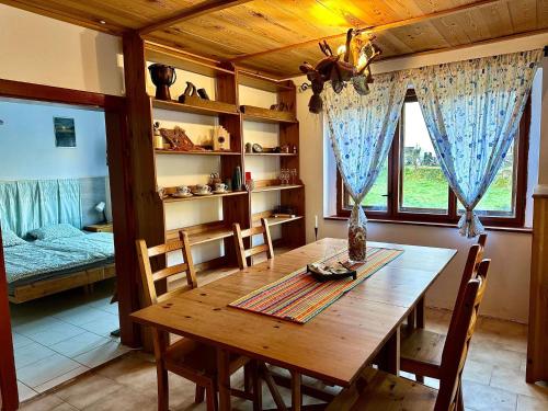 uma sala de jantar com uma mesa de madeira e um quarto em Rakousy22 em Rakousy