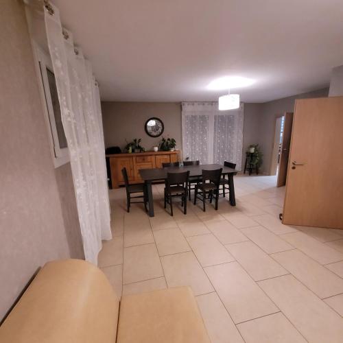 une salle à manger et un salon avec une table et des chaises dans l'établissement Charmante maison équipée pour un séjour agréable, à Valmont
