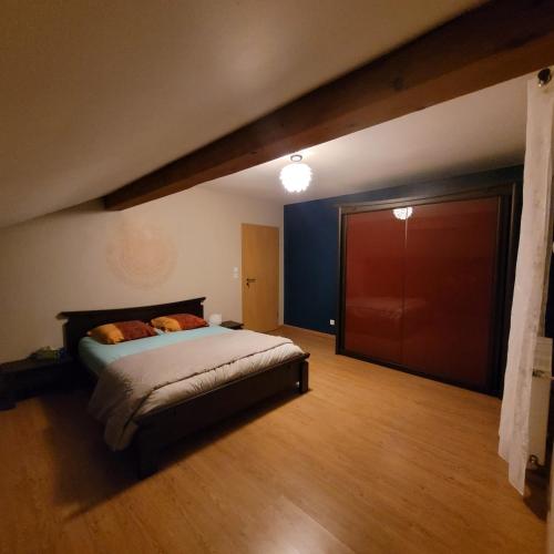 une chambre avec un lit et un parquet dans l'établissement Charmante maison équipée pour un séjour agréable, à Valmont