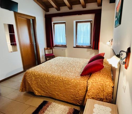 a bedroom with a bed with red pillows on it at Agriturismo Luis Gianni in Cividale del Friuli