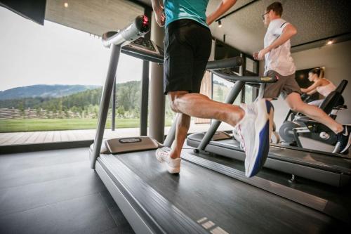 two people on a treadmill in a gym at Almwellness Hotel Pierer in Fladnitz an der Teichalm