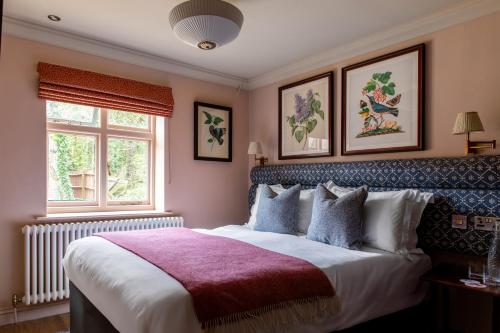 a bedroom with a large bed and two windows at The Carnarvon Arms in Newbury