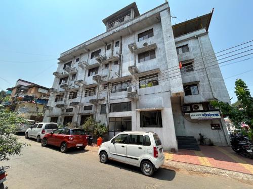 a white car parked in front of a building at Hotel Aaba's Gomantak in Sawantwadi