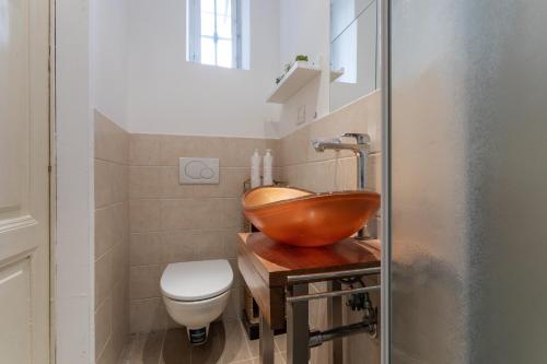a bathroom with a bowl sink and a toilet at L'angolo di Piazza Castello by Wonderful Italy in Turin