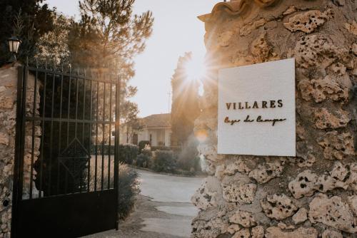 a sign on the side of a stone wall with a gate at Casa de campo Villares in Dosbarrios
