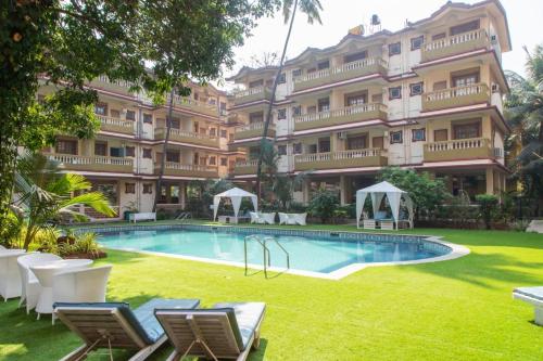 un gran edificio de apartamentos con un patio con piscina en 2bhk with Swimming pool & Kitchen, en Candolim