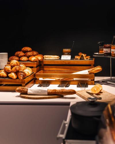 a table topped with lots of bread and pastries at Hôtel du Château Dinan - Originals Boutique in Dinan