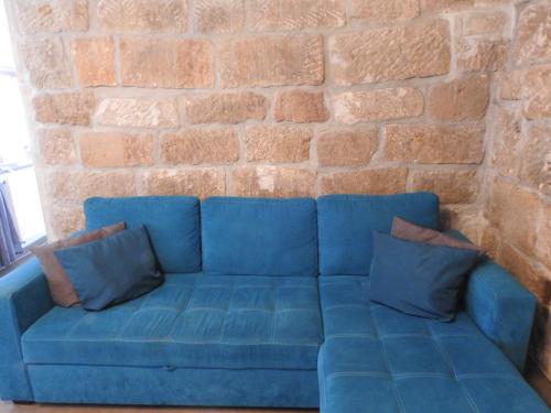 a blue couch in front of a brick wall at Ferienwohnungen am Hauptplatz in Pirna
