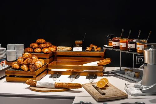 a display of bread and pastries on a table at Hôtel du Château Dinan - Originals Boutique in Dinan
