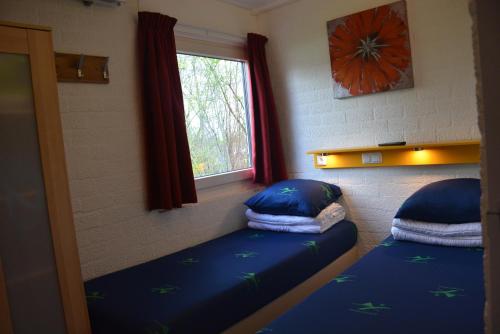 een slaapkamer met 2 bedden en een raam bij Vakantiehuis Rosa in Simpelveld