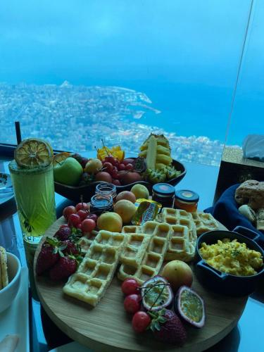a tray of food with waffles and fruit on a table at Bay Lodge Boutique Hotel in Jounieh