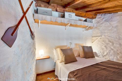 a bedroom with a bed in a stone wall at Casa Luciana, TerreMarine, Trekking and Nature in La Spezia