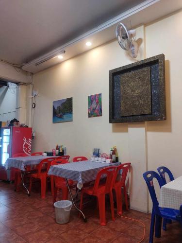 un ristorante con tavoli, sedie e ventilatore di Mabuhay Guest House a Vientiane