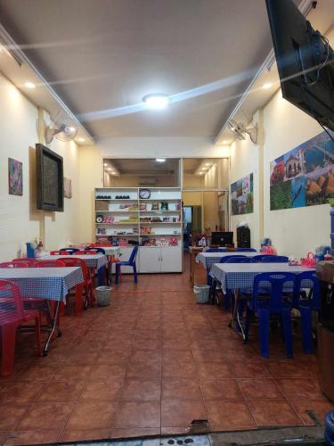 una sala da pranzo con tavoli e sedie blu e rosse di Mabuhay Guest House a Vientiane