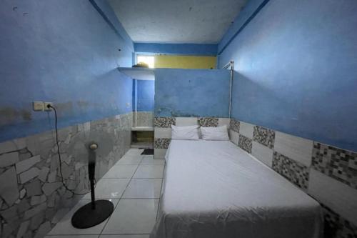 una piccola camera con letto in una camera blu di SPOT ON 93879 Wunut Homestay Syariah a Sidoarjo