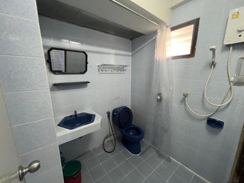 a bathroom with a blue toilet and a sink at Prontip Place in Godown