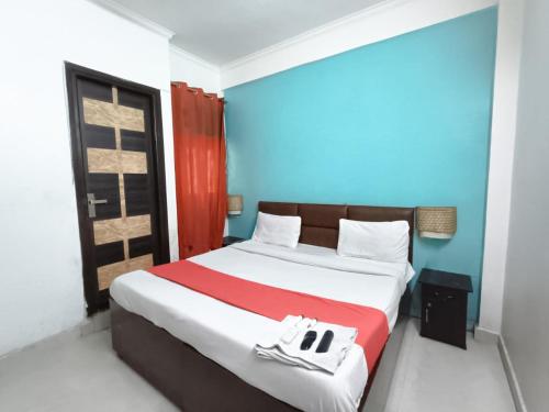 a bedroom with a bed with a red and blue wall at Roomshala 172 Hotel Blue Moon - Satya Niketan in New Delhi
