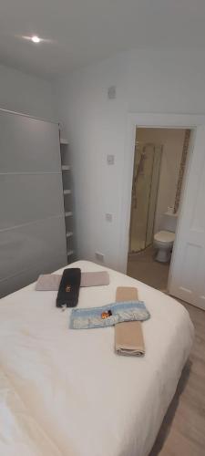 a white bed with a laptop and a tie on it at Cosy One Bedroom Apartment Ballsbridge in Dublin