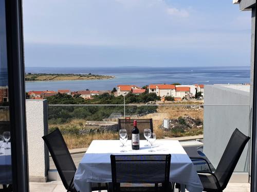 einen Tisch mit einer Flasche Wein auf dem Balkon in der Unterkunft Villa Apartments AniFil in Novalja
