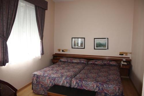 a hotel room with a bed and a window at Hotel Las Sirenas in Viveiro