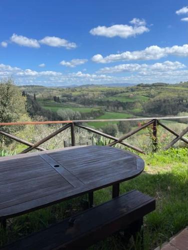 a wooden bench sitting on top of a hill at Casa Dell'Arte Botanica in Palaia