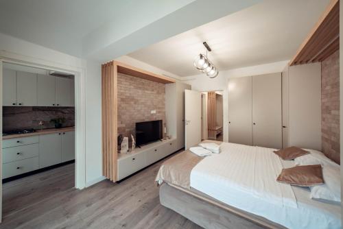 1 dormitorio con 1 cama grande y pared de ladrillo en Palace of Culture & Palas Mall Collection Suites & Studios en Iaşi