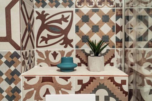 ein Badezimmer mit einem Tisch und einer Pflanze darauf in der Unterkunft Palace of Culture & Palas Mall Collection Suites & Studios in Iaşi