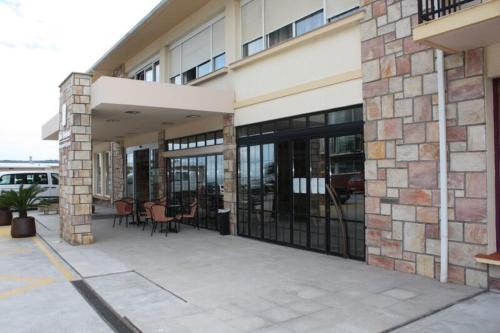 a building with glass doors with tables and chairs at Hotel Las Sirenas in Viveiro