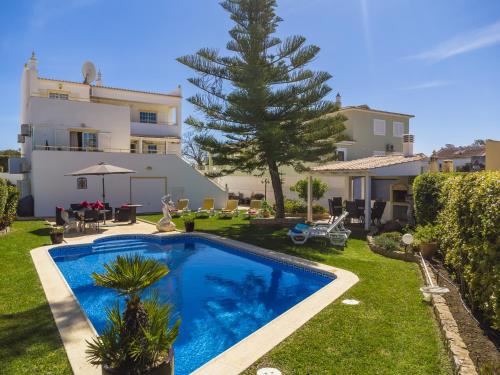 a villa with a swimming pool in front of a house at Villa Glamour by Portucasa in Armação de Pêra