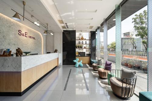 un vestíbulo de una tienda con barra y sillas en S&E Hotel, en Tainan